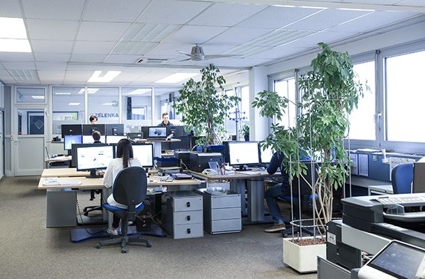 Ein Büroraum mit vielen Bildschirmen, Pflanzen und Mitarbeitern